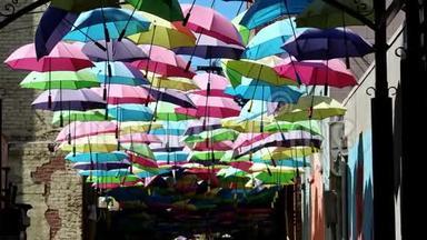 五颜六色的雨伞挂在著名的橘子街巷里